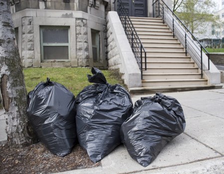 Operative assessing risks before lifting and loading waste